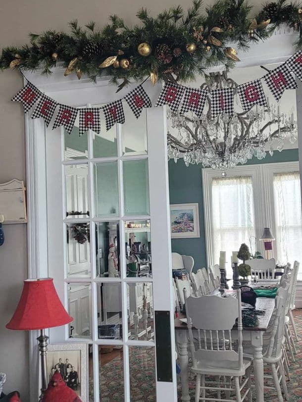A festive room features a "Merry & Bright" banner, holiday décor, and a chandelier.