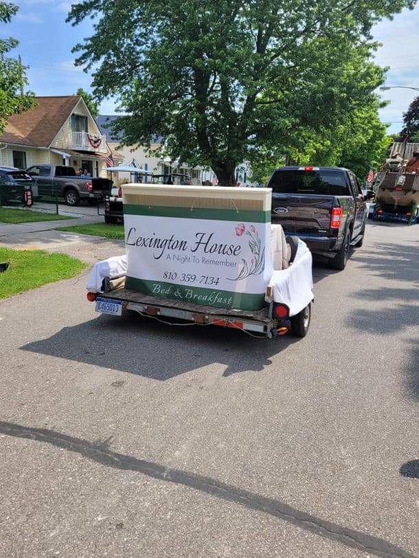 A trailer advertising "Lexington House Bed & Breakfast" parked on a residential street.